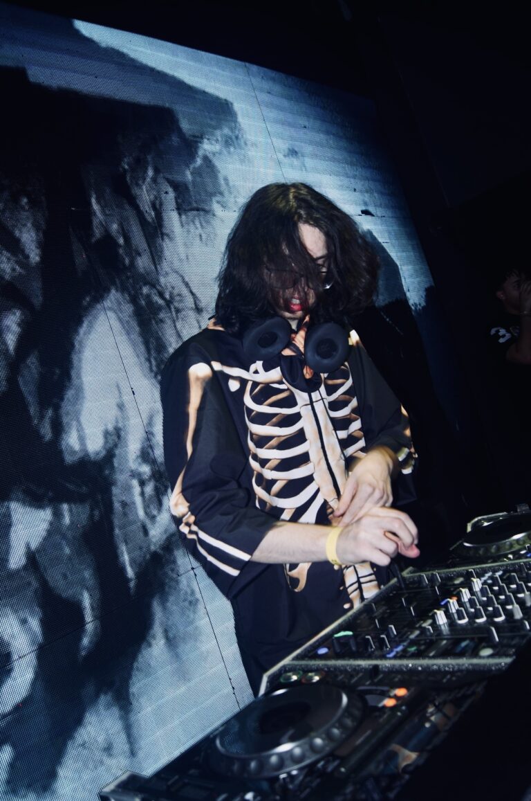 DJ de jaqueta de esqueleto ajusta o mixer — Sad Baile Joker, Halloween em São Paulo, 17/10/2026