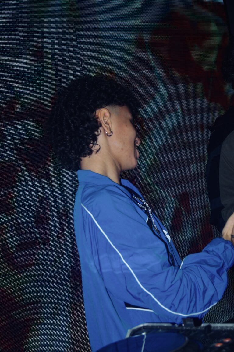 DJ de jaqueta azul de lado sob luz baixa — Sad Baile Joker, Halloween em São Paulo, 17/10/2026
