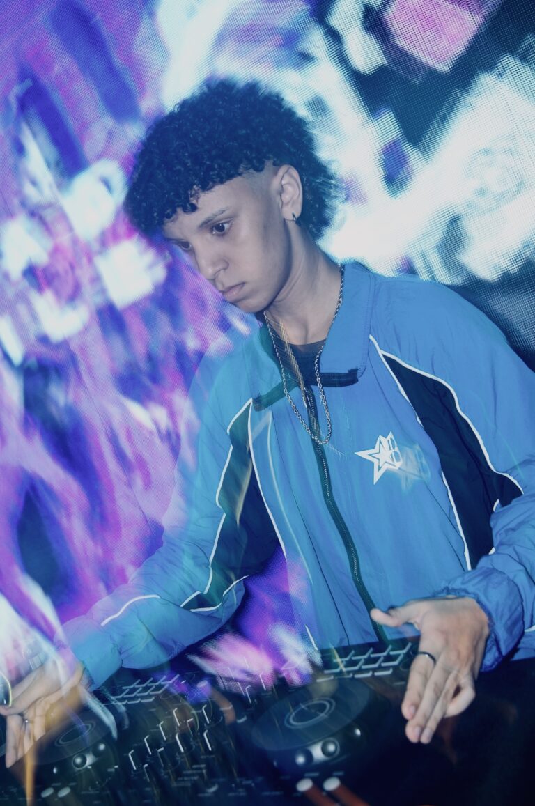 DJ de jaqueta azul com efeito de luz roxa — Sad Baile Joker, Halloween em São Paulo, 17/10/2026