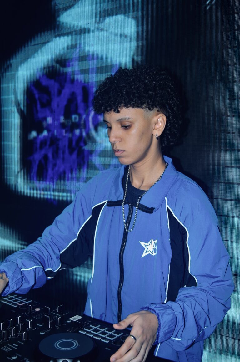 DJ de jaqueta azul diante do logo da Sad Baile — Sad Baile Joker, Halloween em São Paulo, 17/10/2026