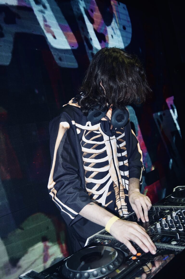 DJ de jaqueta de esqueleto com a cabeça baixa — Sad Baile Joker, Halloween em São Paulo, 17/10/2026