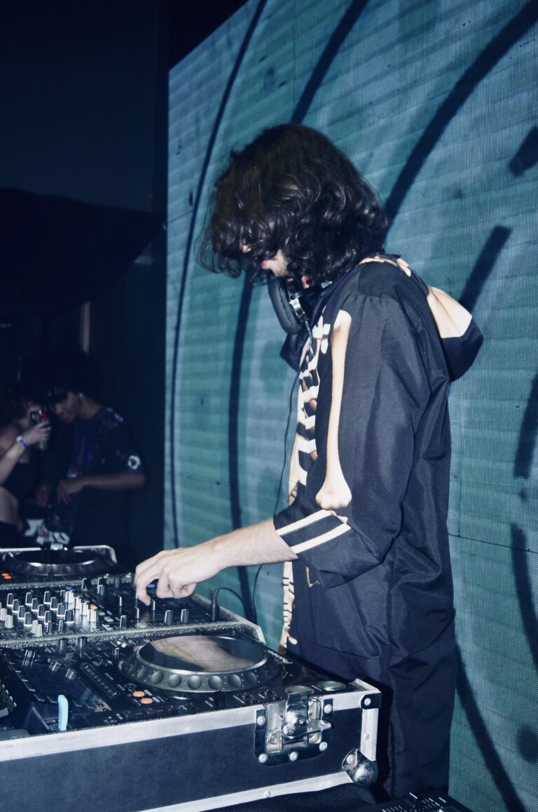 DJ de jaqueta de esqueleto de costas diante do telão — Sad Baile Joker, Halloween em São Paulo, 17/10/2026