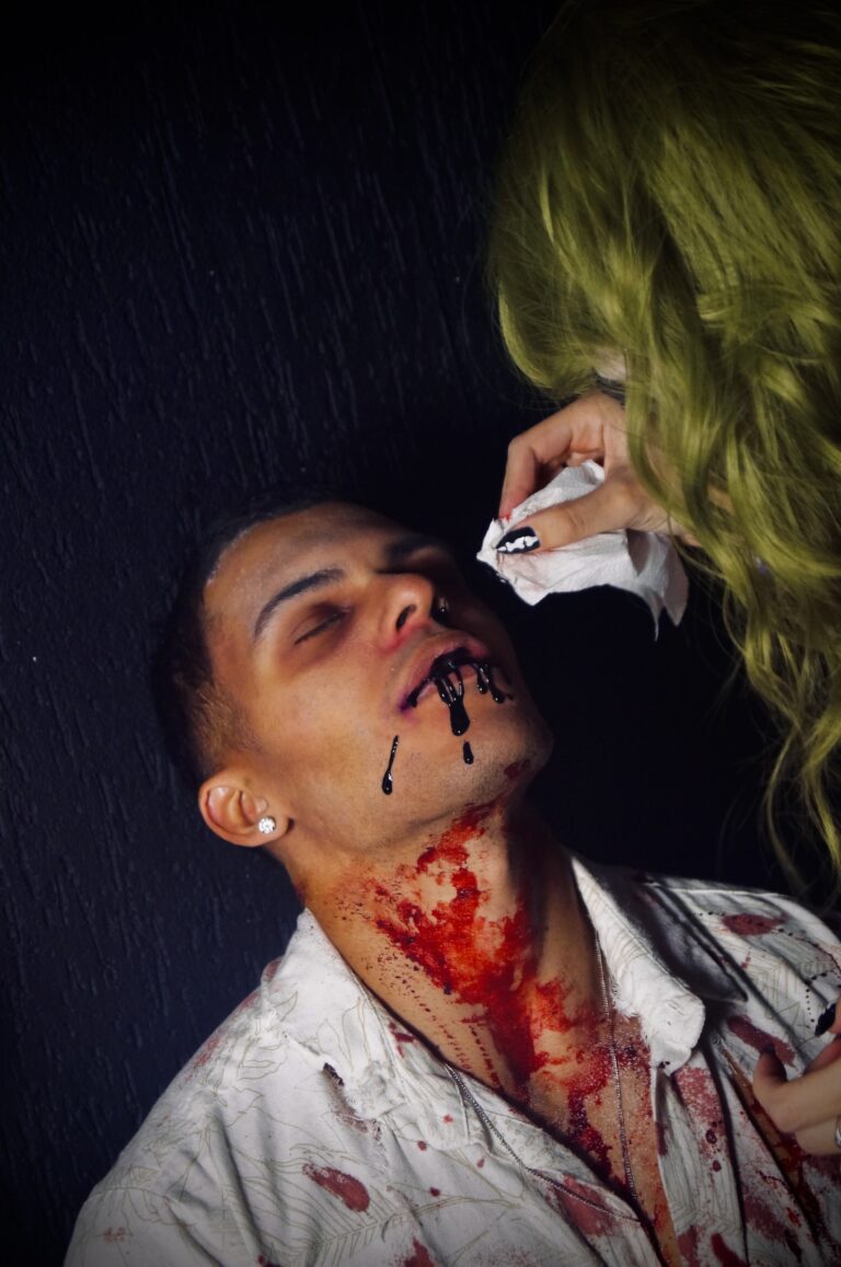 Maquiadora de peruca verde pinta o rosto de um rapaz — Sad Baile Joker, Halloween em São Paulo, 17/10/2026