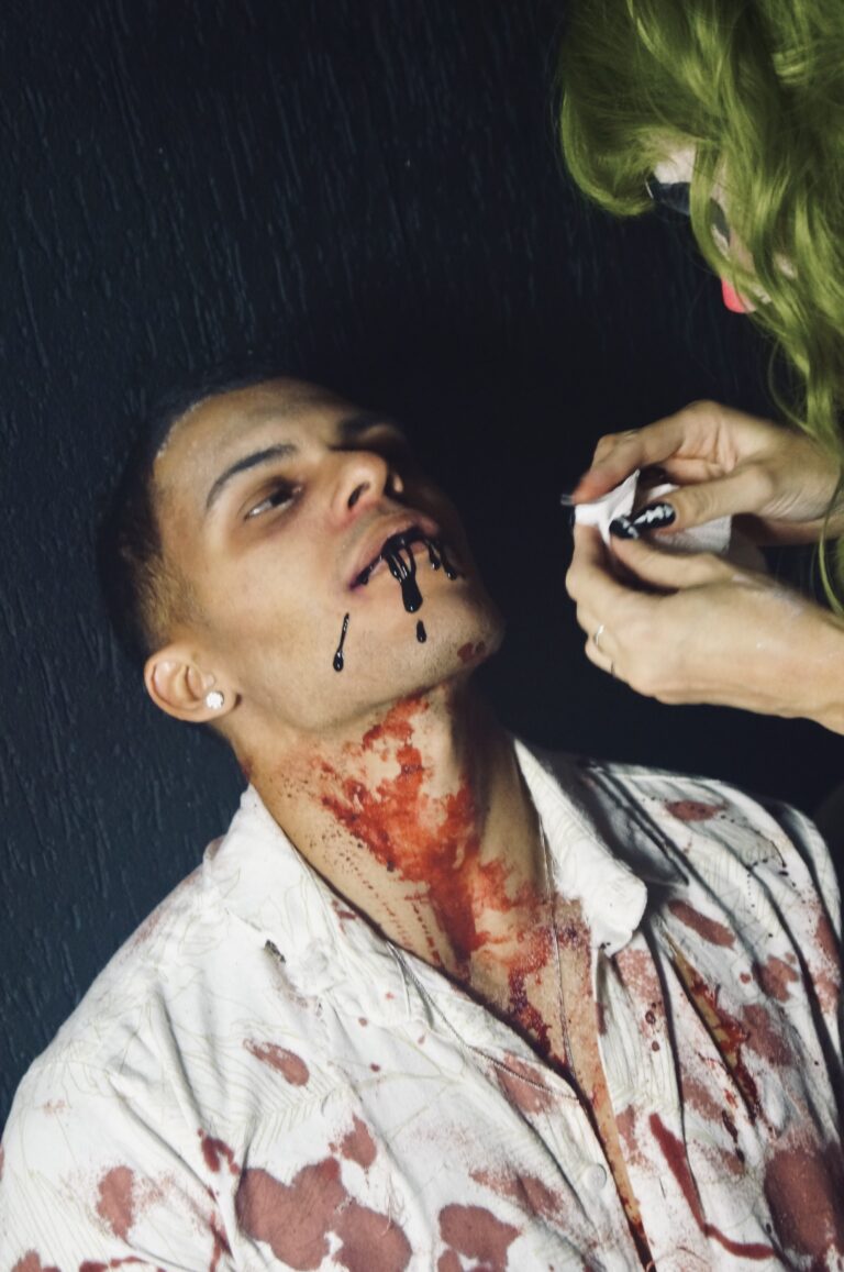 Maquiadora aplica sangue falso na boca de um rapaz — Sad Baile Joker, Halloween em São Paulo, 17/10/2026