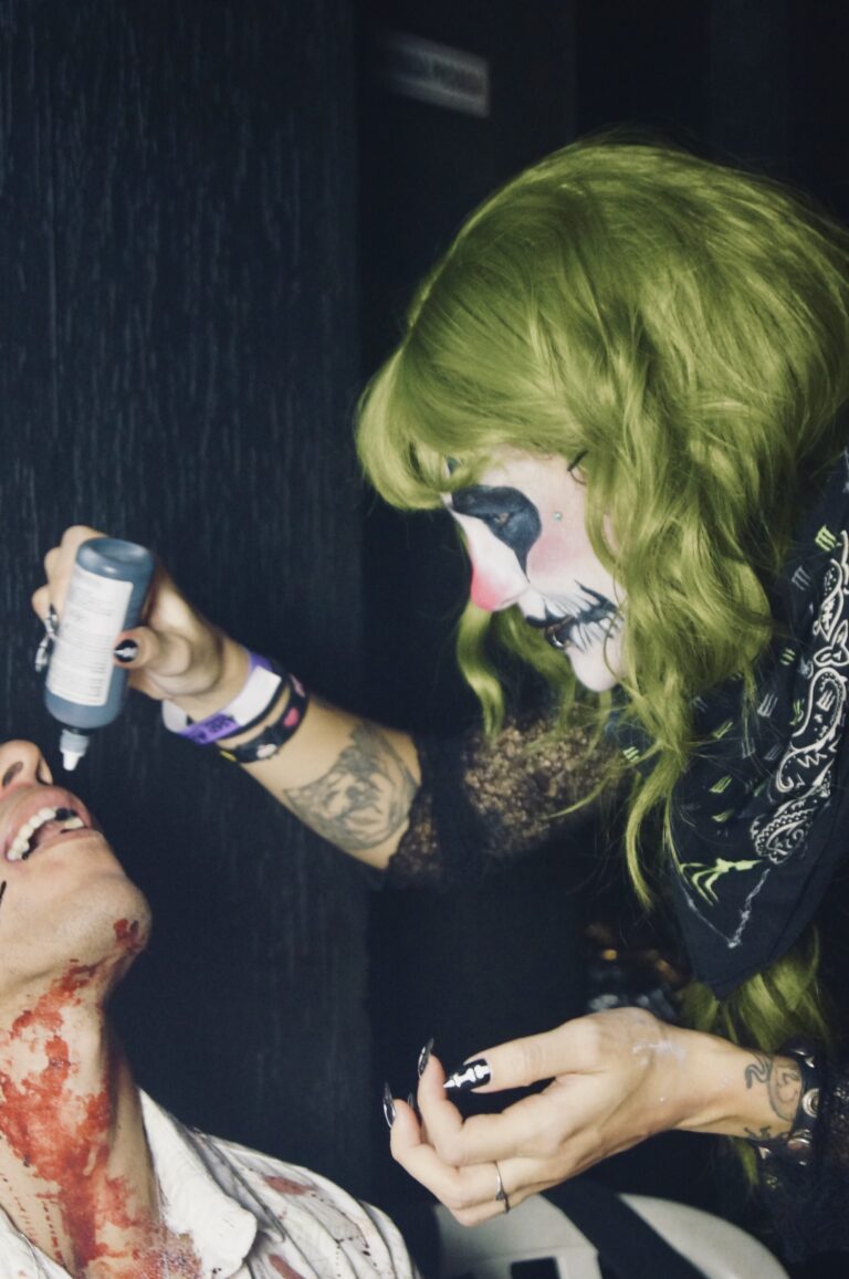 Maquiadora de palhaço segura o frasco de sangue falso — Sad Baile Joker, Halloween em São Paulo, 17/10/2026