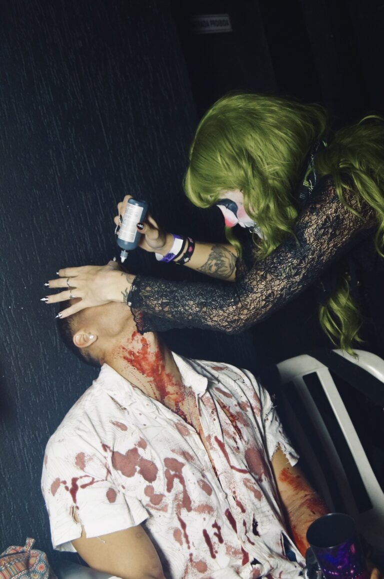 Participante recebe sangue falso no pescoço — Sad Baile Joker, Halloween em São Paulo, 17/10/2026