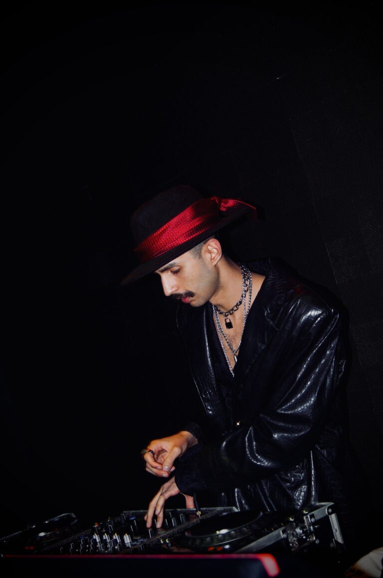 DJ de chapéu nos controles sob luz baixa — Sad Baile Joker, Halloween em São Paulo, 17/10/2026