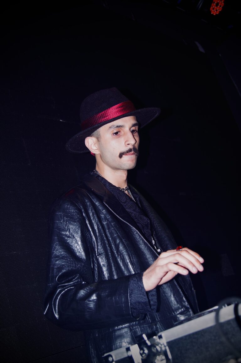 DJ de chapéu de bigode olha para a pista — Sad Baile Joker, Halloween em São Paulo, 17/10/2026
