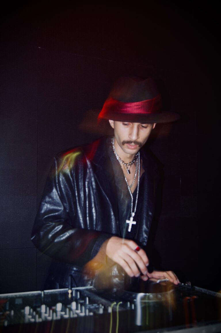 DJ de chapéu com crucifixo no peito nos controles — Sad Baile Joker, Halloween em São Paulo, 17/10/2026