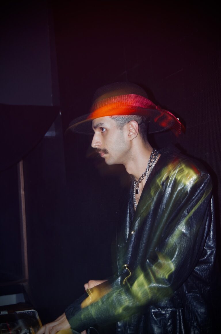 DJ de chapéu e jaqueta de couro sob luz vermelha — Sad Baile Joker, Halloween em São Paulo, 17/10/2026