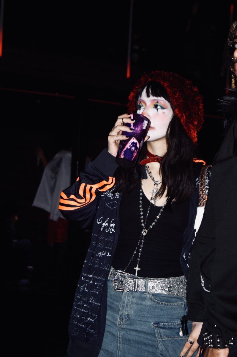 Garota de cabelo vermelho bebe no copo Joker — Sad Baile Joker, Halloween em São Paulo, 17/10/2026