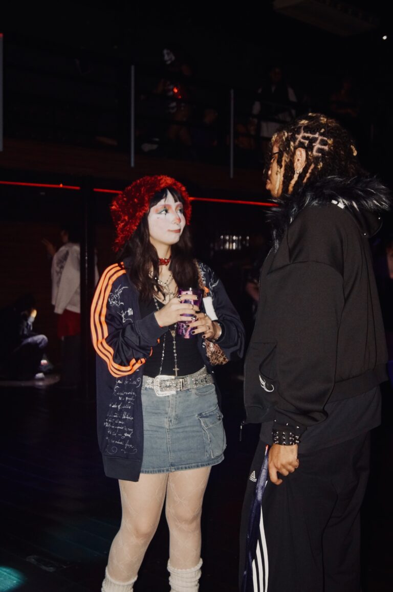 Garota de saia jeans conversa com amigo — Sad Baile Joker, Halloween em São Paulo, 17/10/2026