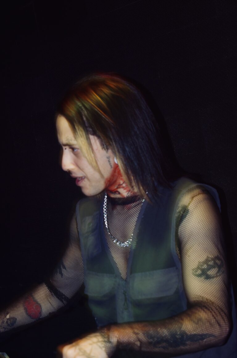 DJ de cabelo comprido mixando sob luz baixa — Sad Baile Joker, Halloween em São Paulo, 17/10/2026