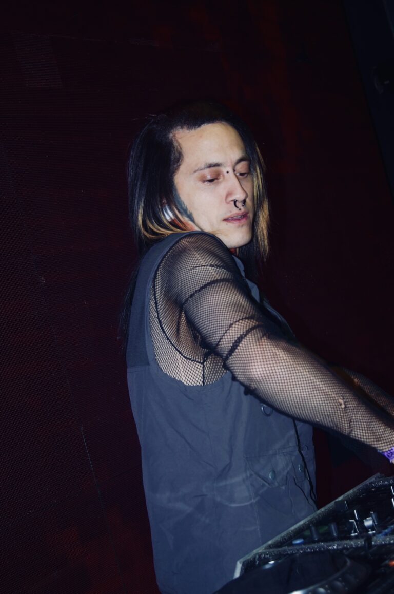 DJ de cabelo comprido sob luz vermelha — Sad Baile Joker, Halloween em São Paulo, 17/10/2026
