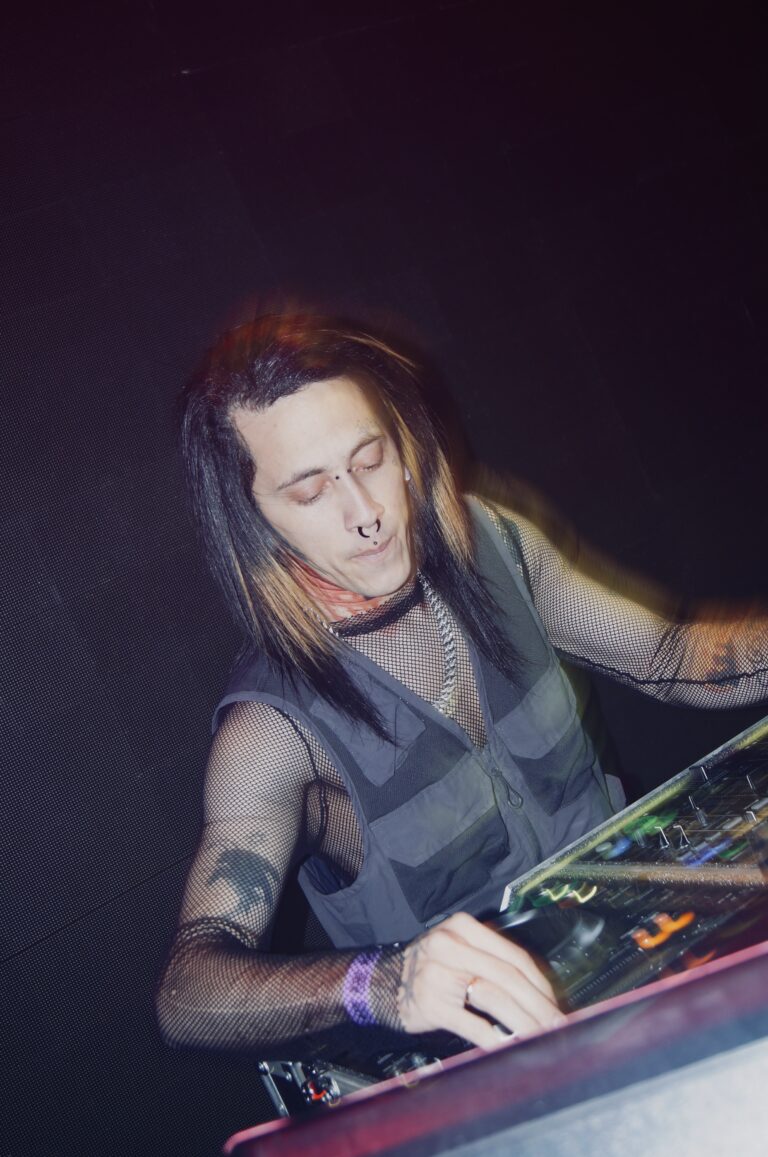 DJ de cabelo comprido sorri nos controles — Sad Baile Joker, Halloween em São Paulo, 17/10/2026