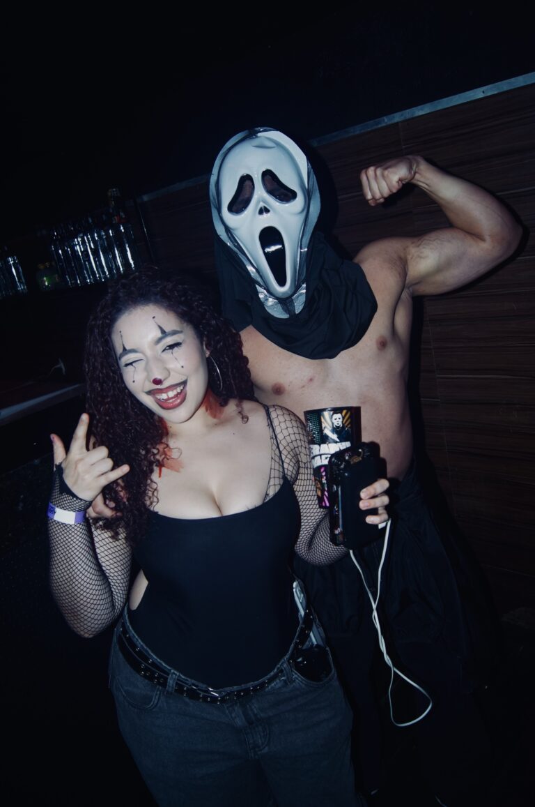Amiga sorri ao lado do Ghostface na pista — Sad Baile Joker, Halloween em São Paulo, 17/10/2026