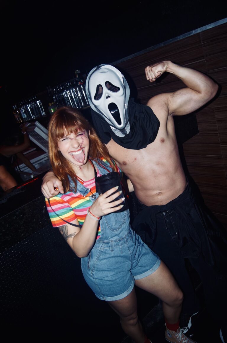 Garota de blusa arco-íris com Ghostface sem camisa — Sad Baile Joker, Halloween em São Paulo, 17/10/2026
