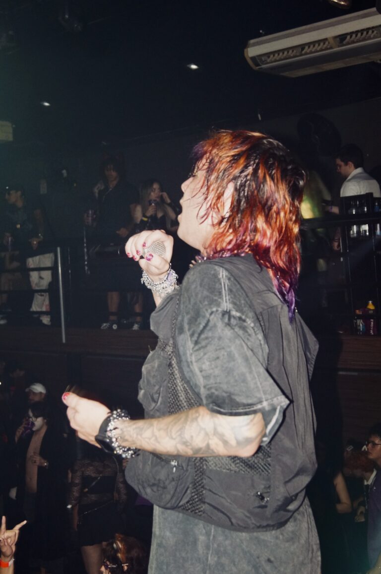 Artista canta de olhos fechados no palco — Sad Baile Joker, Halloween em São Paulo, 17/10/2026