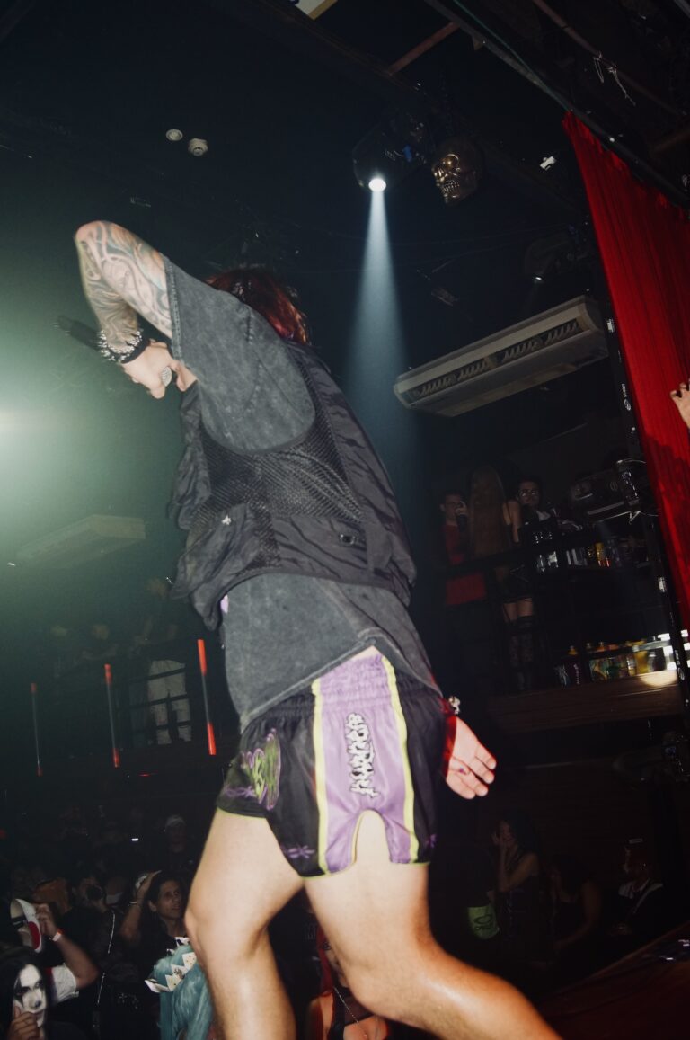 Artista dança com o braço sobre o rosto — Sad Baile Joker, Halloween em São Paulo, 17/10/2026