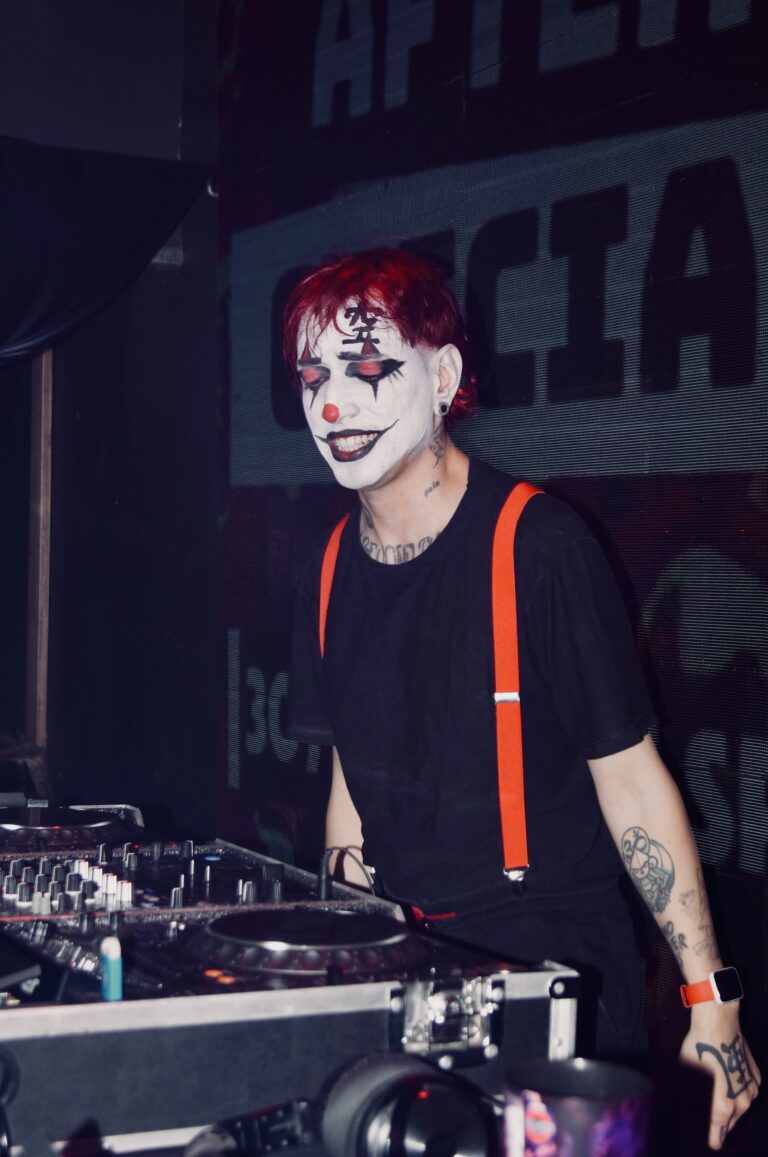 DJ de rosto pintado sorri diante do telão do after — Sad Baile Joker, Halloween em São Paulo, 17/10/2026