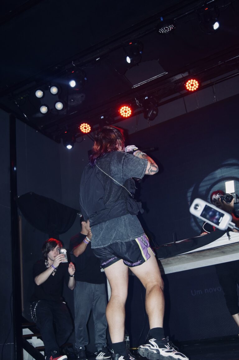 Artista de costas no palco com a equipe ao lado — Sad Baile Joker, Halloween em São Paulo, 17/10/2026