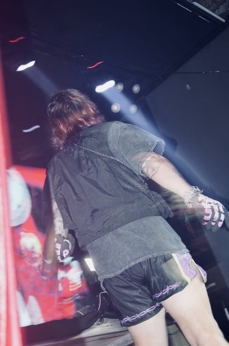 Artista de costas sob luz roxa — Sad Baile Joker, Halloween em São Paulo, 17/10/2026