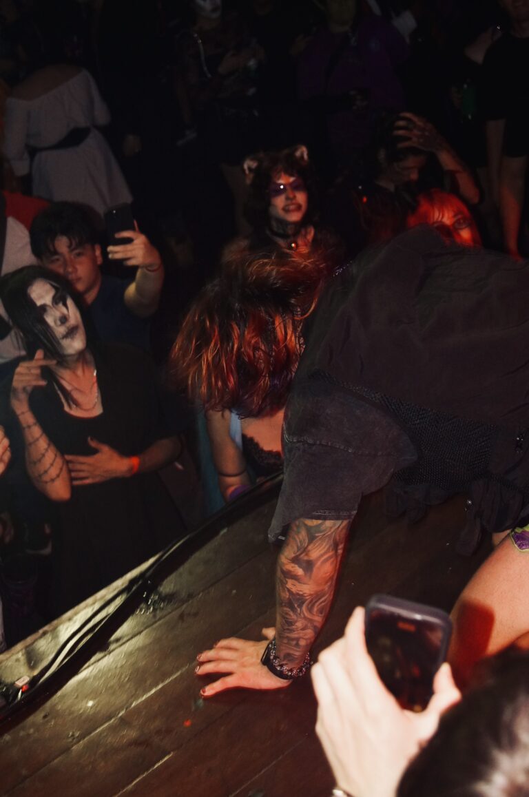 Artista ajoelhado na beira do palco junto ao público — Sad Baile Joker, Halloween em São Paulo, 17/10/2026