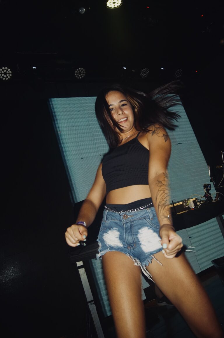 Garota de shorts jeans dança no palco sorrindo — Sad Baile Joker, Halloween em São Paulo, 17/10/2026