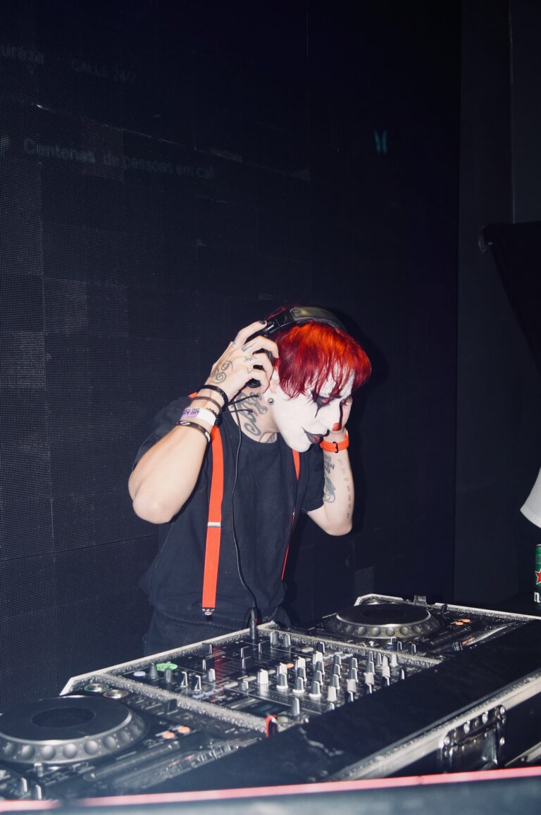 DJ de suspensórios ajeita os fones — Sad Baile Joker, Halloween em São Paulo, 17/10/2026