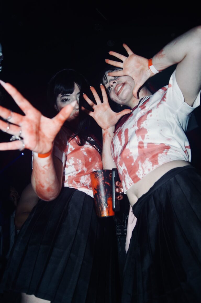 Amigas de colegial ensanguentado fazem pose — Sad Baile Joker, Halloween em São Paulo, 17/10/2026