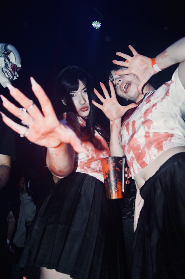 Amigas com maquiagem de sangue fazem pose com as mãos — Sad Baile Joker, Halloween em São Paulo, 17/10/2026