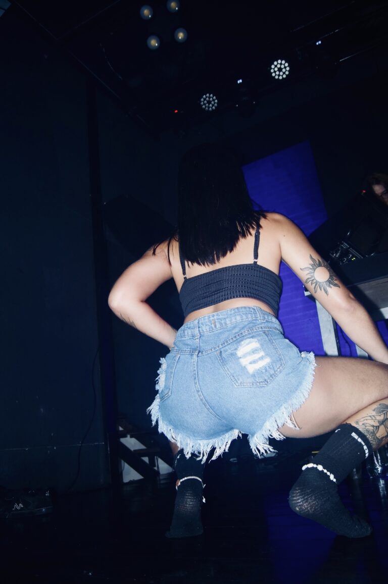 Dançarina de shorts jeans de costas no palco — Sad Baile Joker, Halloween em São Paulo, 17/10/2026