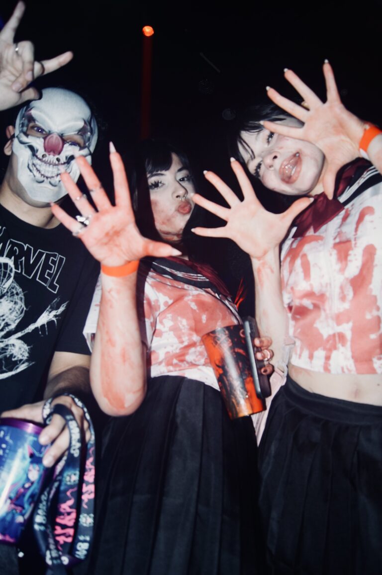 Amigas de blusa manchada de sangue com palhaço ao fundo — Sad Baile Joker, Halloween em São Paulo, 17/10/2026