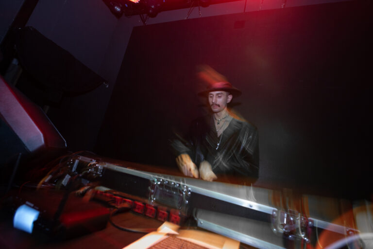 DJ de chapéu na cabine sob luz vermelha — Sad Baile Joker, Halloween em São Paulo, 17/10/2026