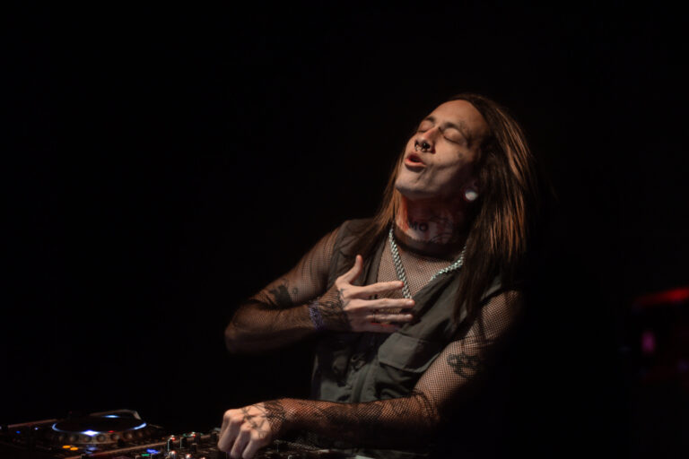 DJ de cabelo comprido sorri olhando para cima — Sad Baile Joker, Halloween em São Paulo, 17/10/2026