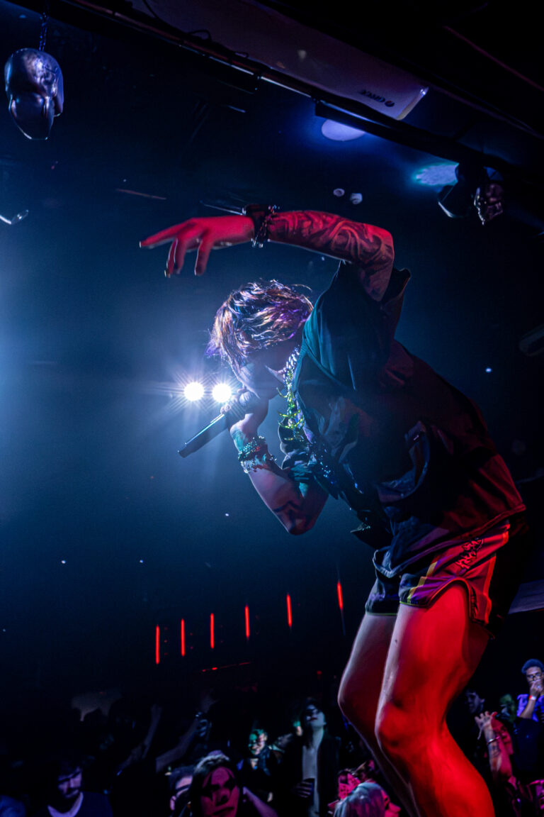 Artista de cocar vermelho dança no palco — Sad Baile Joker, Halloween em São Paulo, 17/10/2026