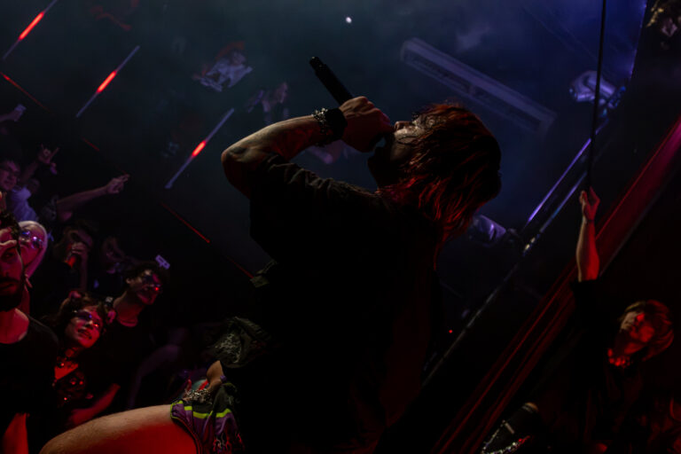 Rapper canta de costas para a câmera diante da plateia — Sad Baile Joker, Halloween em São Paulo, 17/10/2026
