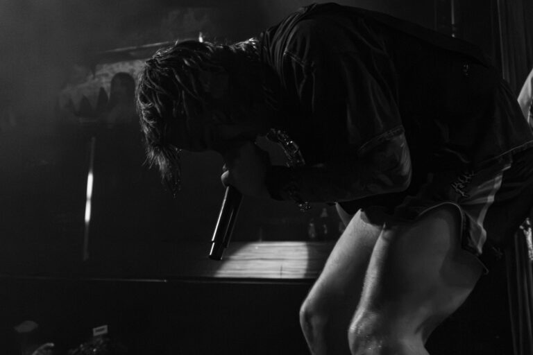 Artista curvado no palco em preto e branco — Sad Baile Joker, Halloween em São Paulo, 17/10/2026
