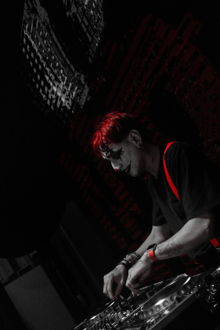 DJ de suspensórios e rosto pintado nos controles — Sad Baile Joker, Halloween em São Paulo, 17/10/2026
