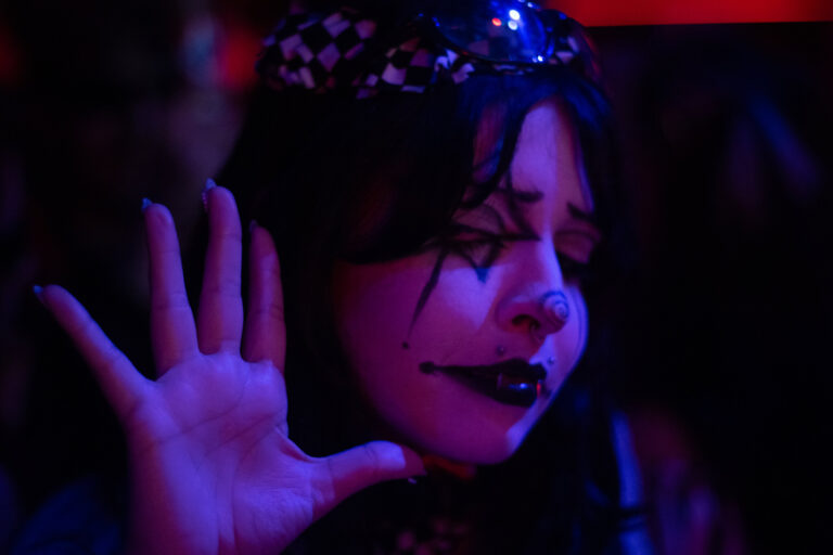Palhaça estende a mão sob luz azul — Sad Baile Joker, Halloween em São Paulo, 17/10/2026