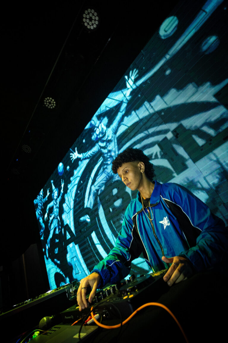 DJ de jaqueta azul diante do telão — Sad Baile Joker, Halloween em São Paulo, 17/10/2026