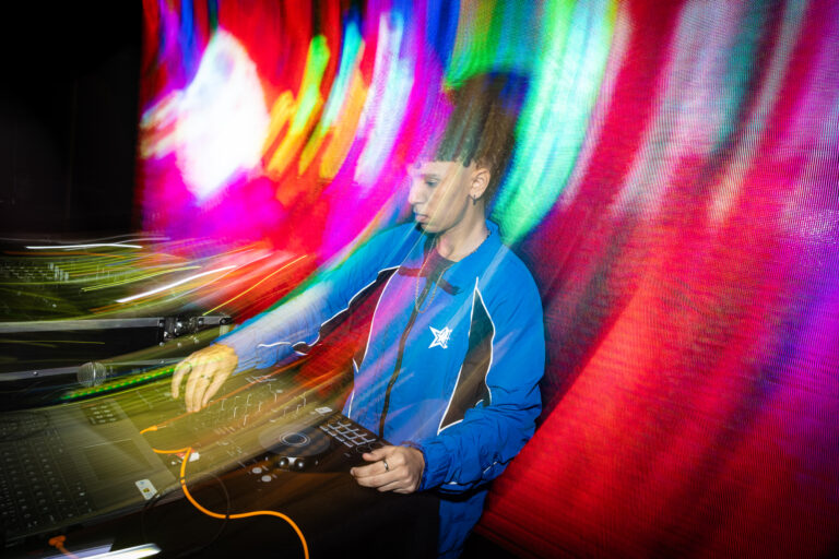 DJ com rastros de luz coloridos — Sad Baile Joker, Halloween em São Paulo, 17/10/2026