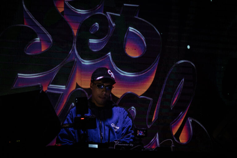Rapper diante do telão grafitado — Sad Baile Joker, Halloween em São Paulo, 17/10/2026