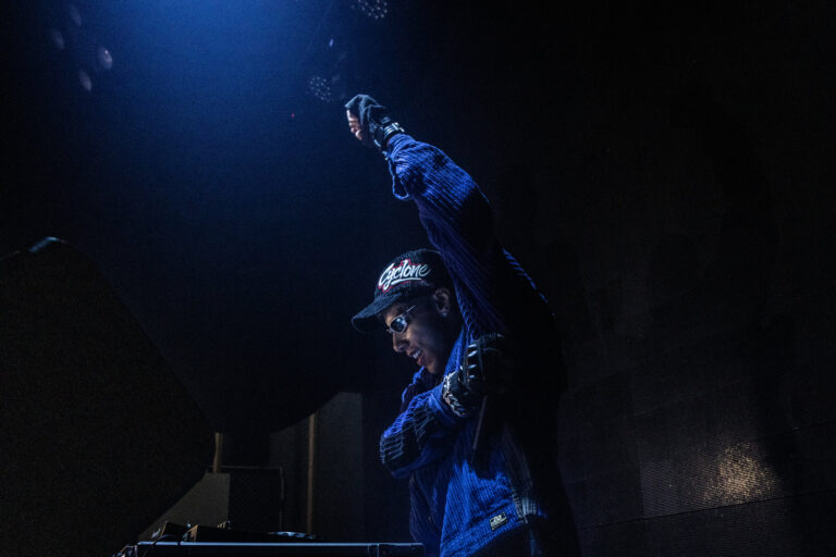 DJ ergue o braço sob luz azul — Sad Baile Joker, Halloween em São Paulo, 17/10/2026