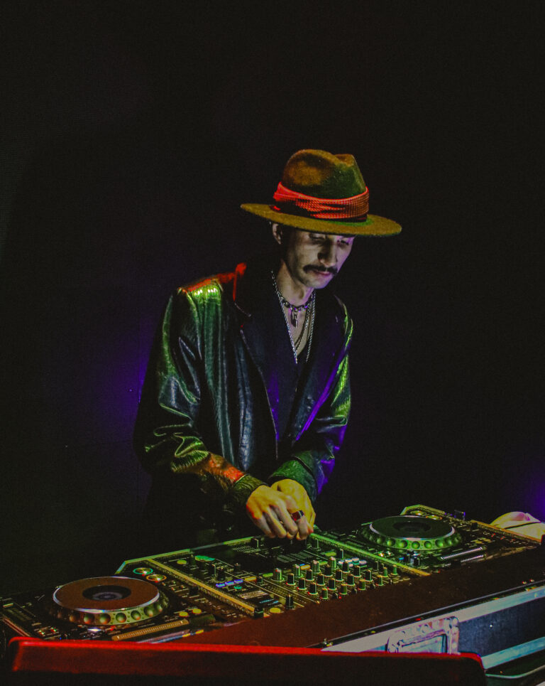 DJ de chapéu ajusta os controles da mesa de som — Sad Baile Joker, Halloween em São Paulo, 17/10/2026