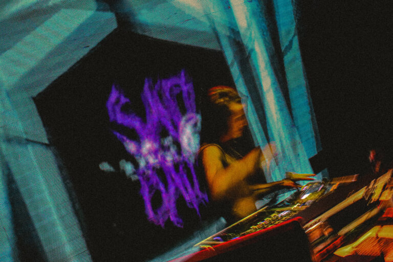 DJ visto de longe com o logo Sad Baile roxo no telão — Sad Baile Joker, Halloween em São Paulo, 17/10/2026