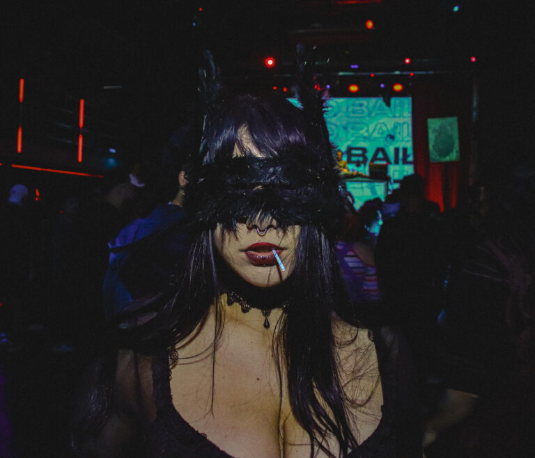 Convidada de máscara de renda e orelhas de gato com cigarro — Sad Baile Joker, Halloween em São Paulo, 17/10/2026