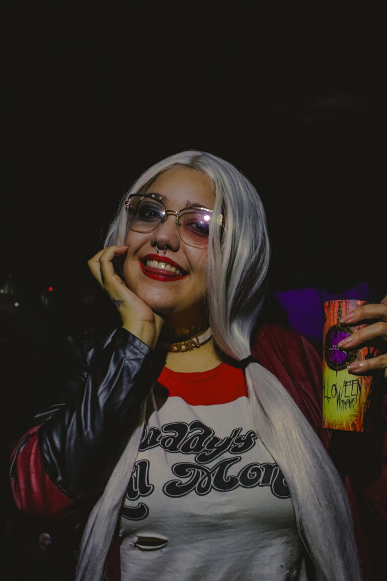 Arlequina de peruca branca sorri olhando para a câmera — Sad Baile Joker, Halloween em São Paulo, 17/10/2026
