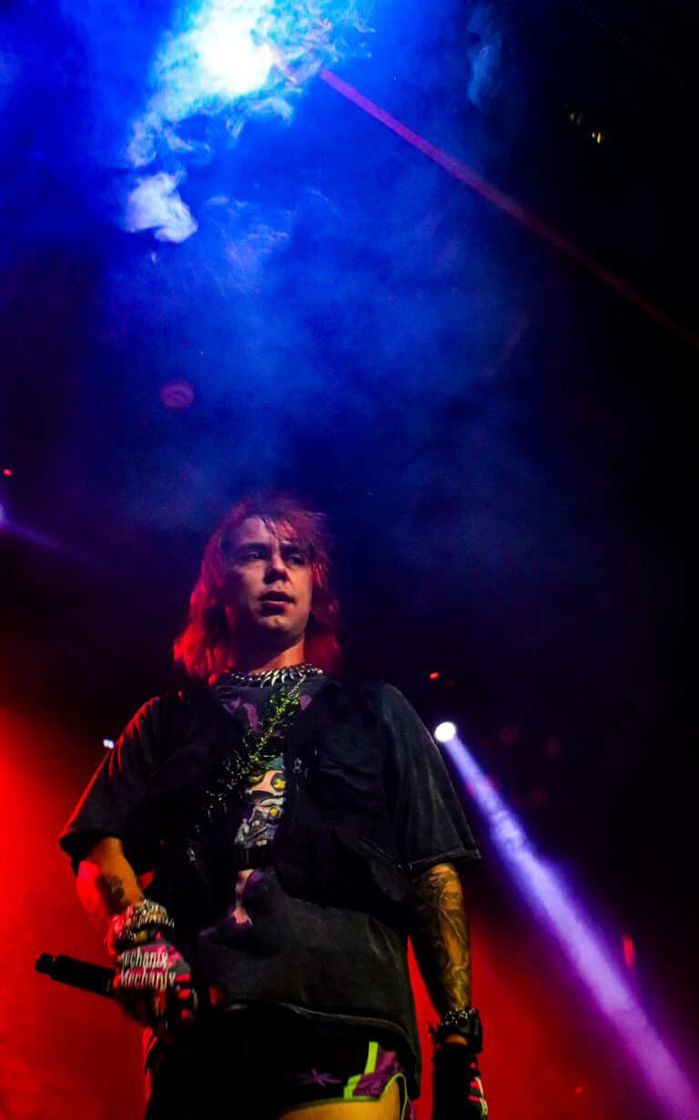 Rapper com microfone sob holofote azul — Sad Baile Joker, Halloween em São Paulo, 17/10/2026