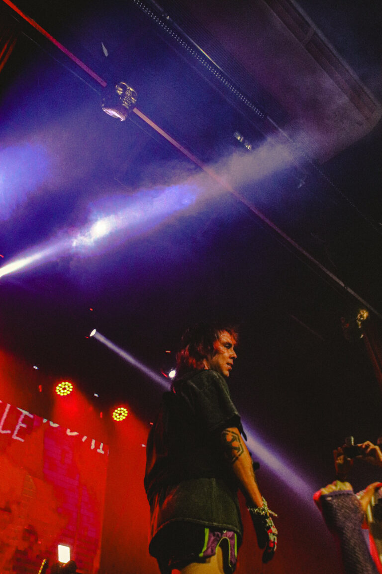 Rapper no canto do palco com feixes de luz roxa — Sad Baile Joker, Halloween em São Paulo, 17/10/2026